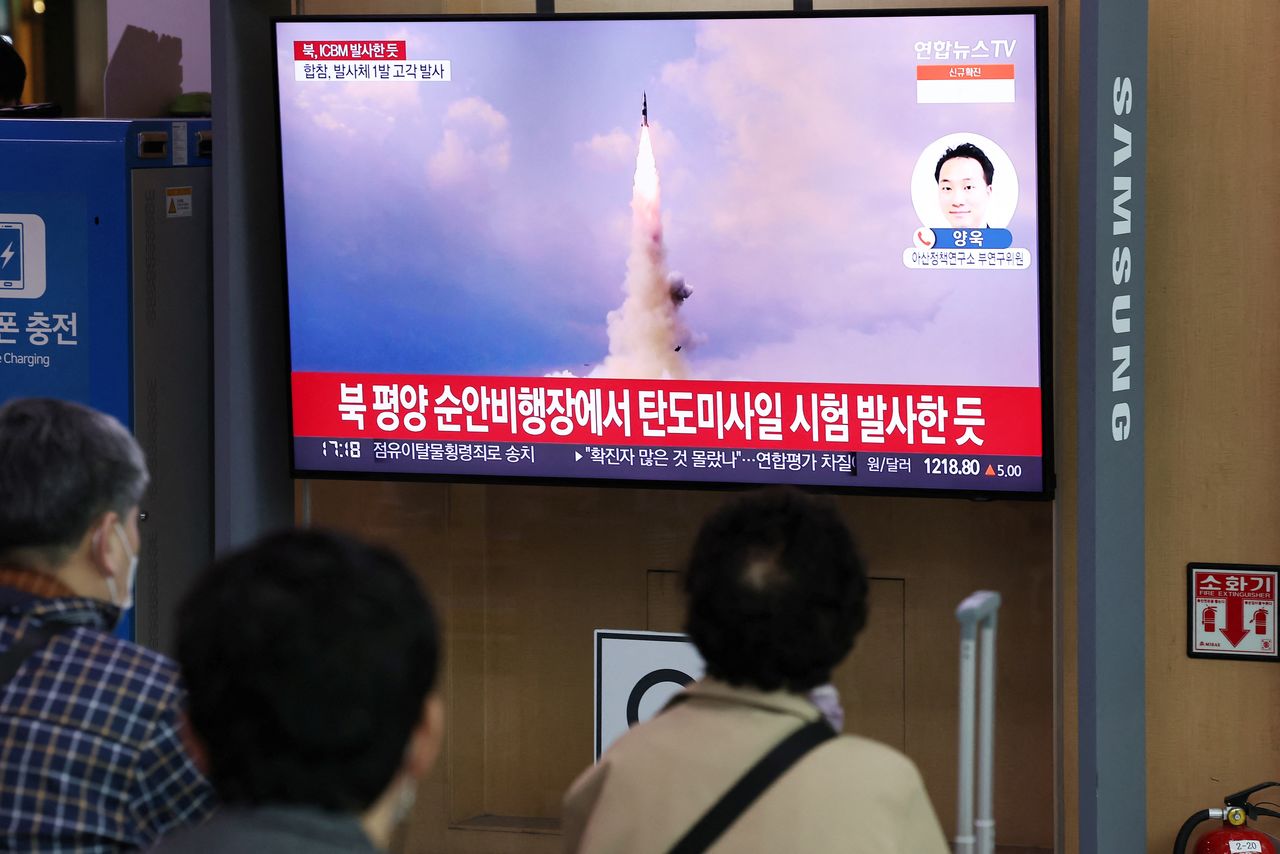 People watch a TV broadcasting a news report on North Korea