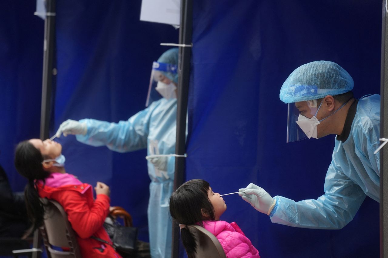 FILE PHOTO: Medical workers take swab samples from residents at a community nucleic acid testing centre for the coronavirus disease (COVID-19) at Sha Tin district, in Hong Kong, China, February 7, 2022. REUTERS/Lam Yik/File Photo