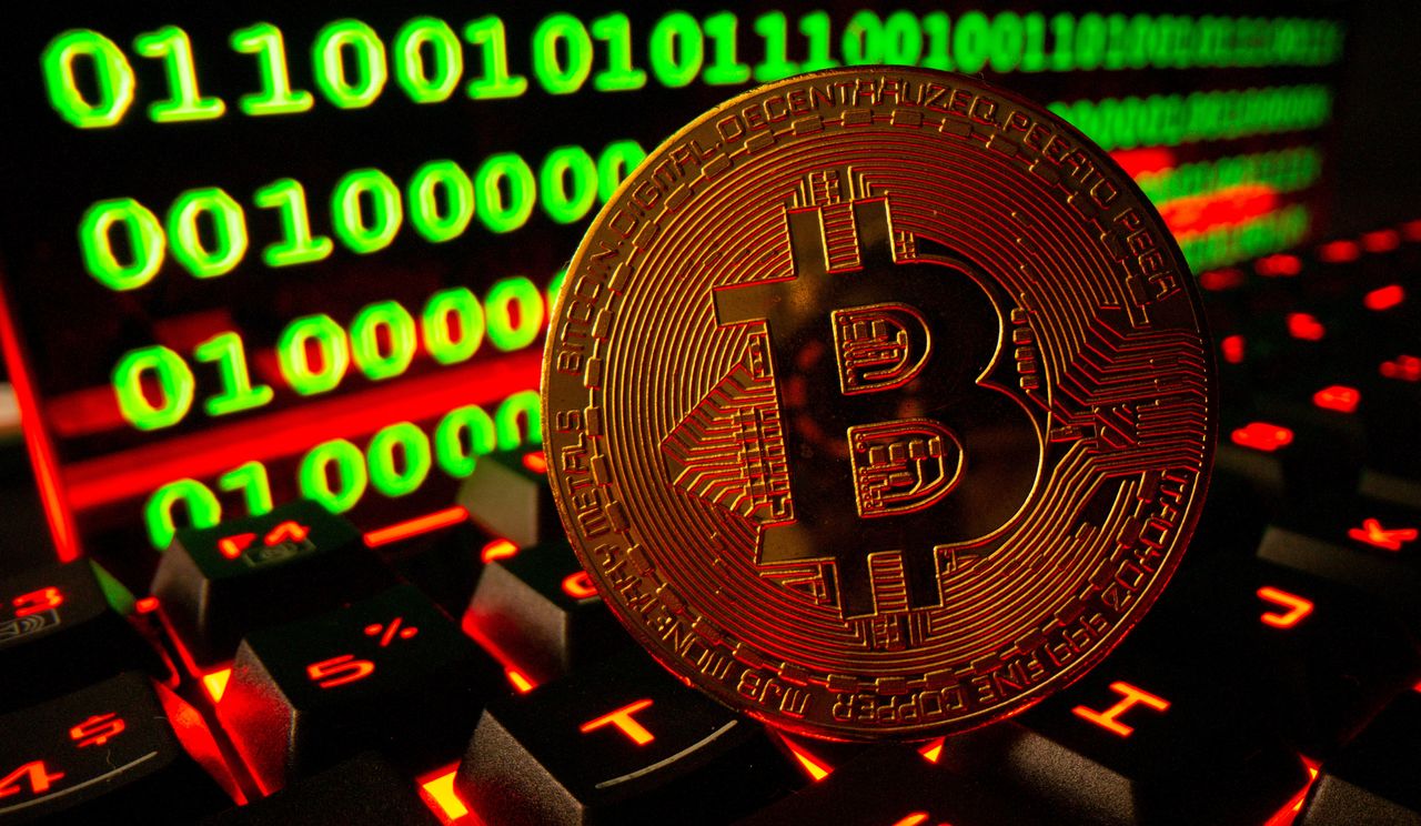 FILE PHOTO: Bitcoin cryptocurrency representation is pictured on a keyboard in front of binary code in this illustration taken September 24, 2021. REUTERS/Dado Ruvic