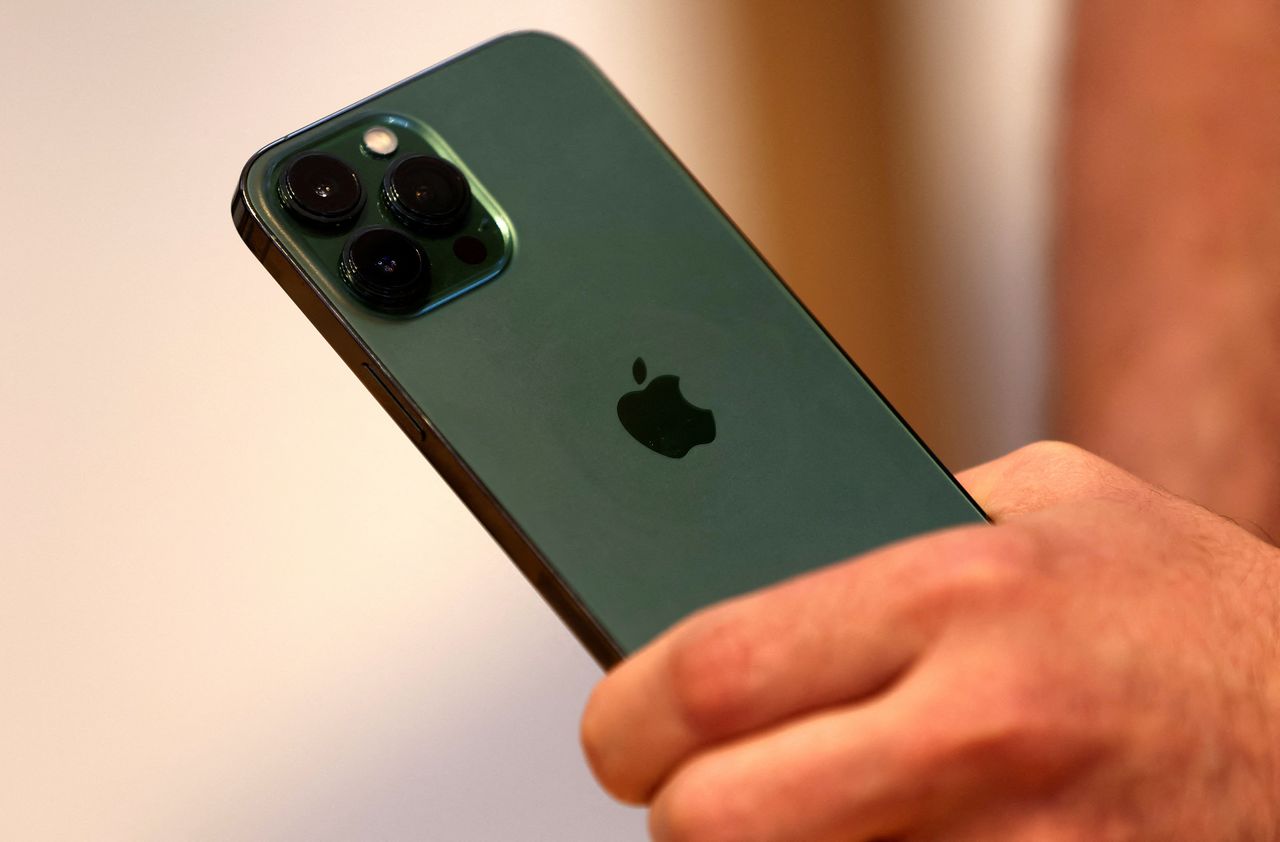 FILE PHOTO: A customers holds the new green colour Apple iPhone 13 pro shortly after it went on sale inside the Apple Store on 5th Avenue in Manhattan in New York City, New York, U.S., March 18, 2022. REUTERS/Mike Segar/