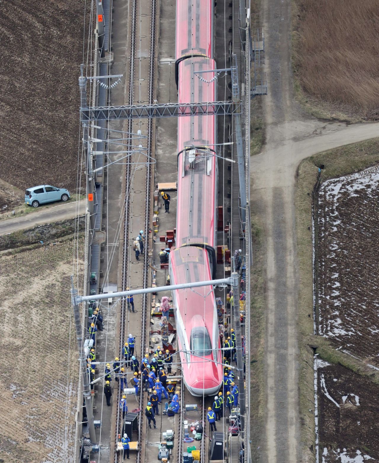 Workers attend to a Tōhoku Shinkansen with derailed cars in Shiroishi, Miyagi Prefecture, on March 20, 2022. (© Jiji)
