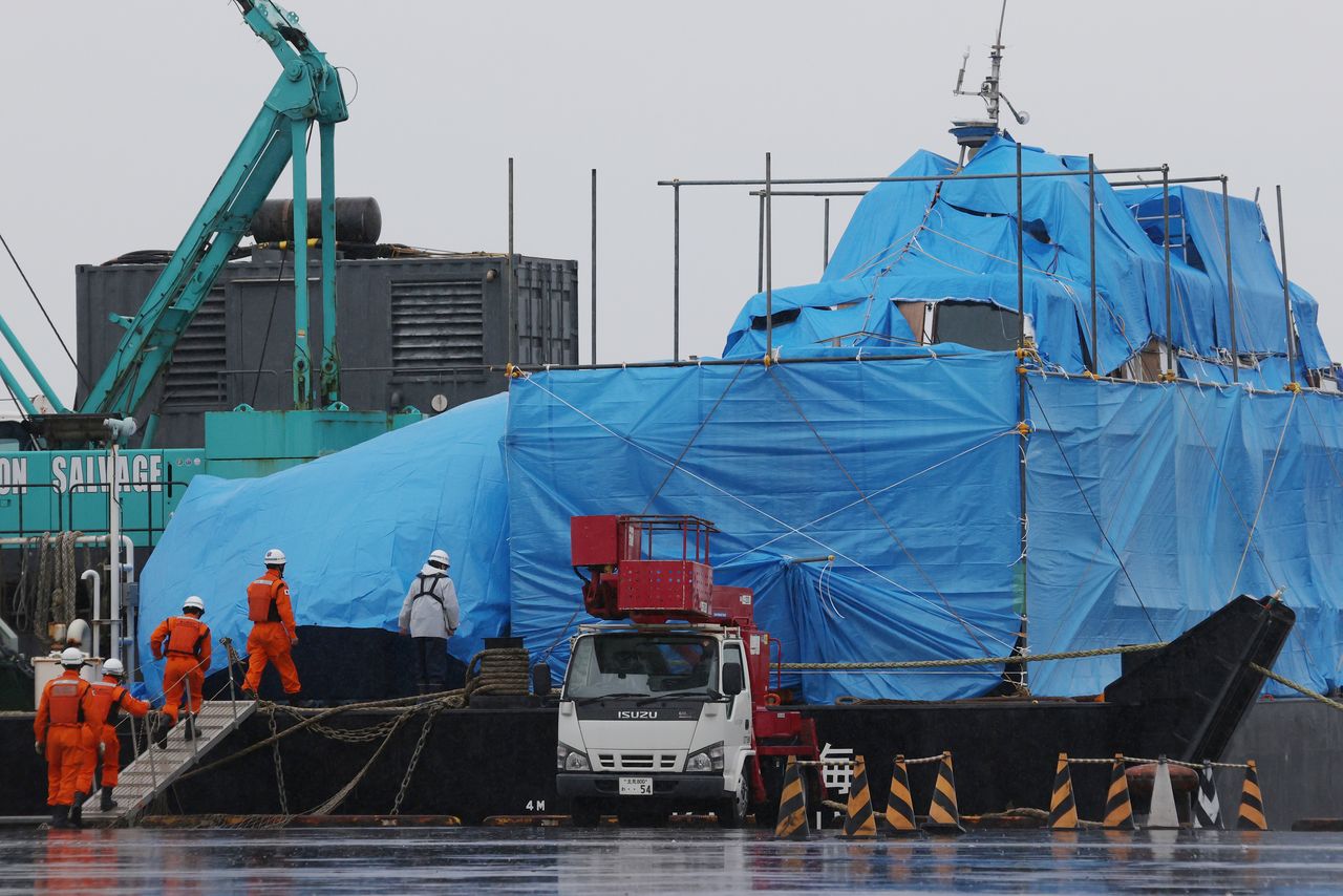 A Japan Coast Guard salvage team (bottom left) investigating the wreckage of the Kazu 1 in Abashiri, Hokkaidō, on May 28, 2022. (© Jiji)