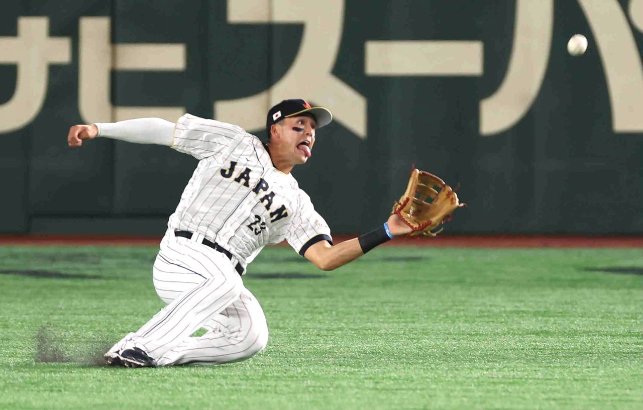 Japan center fielder Lars Nootbar makes a catch during the team’s opening game against China. (© Jiji)