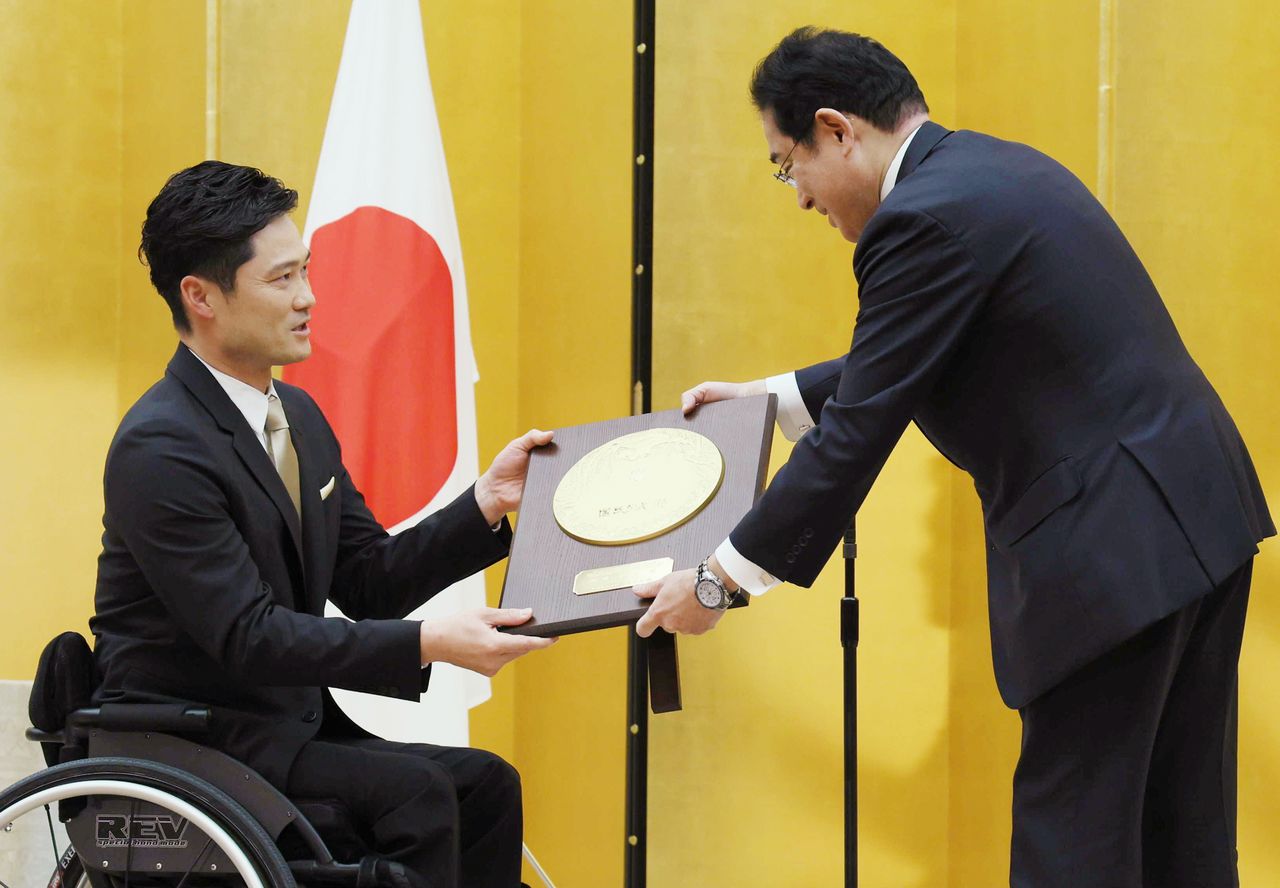 Kunieda Shingo, left, receives the People’s Honor Award from Prime Minister Kishida Fumio. (© Jiji)