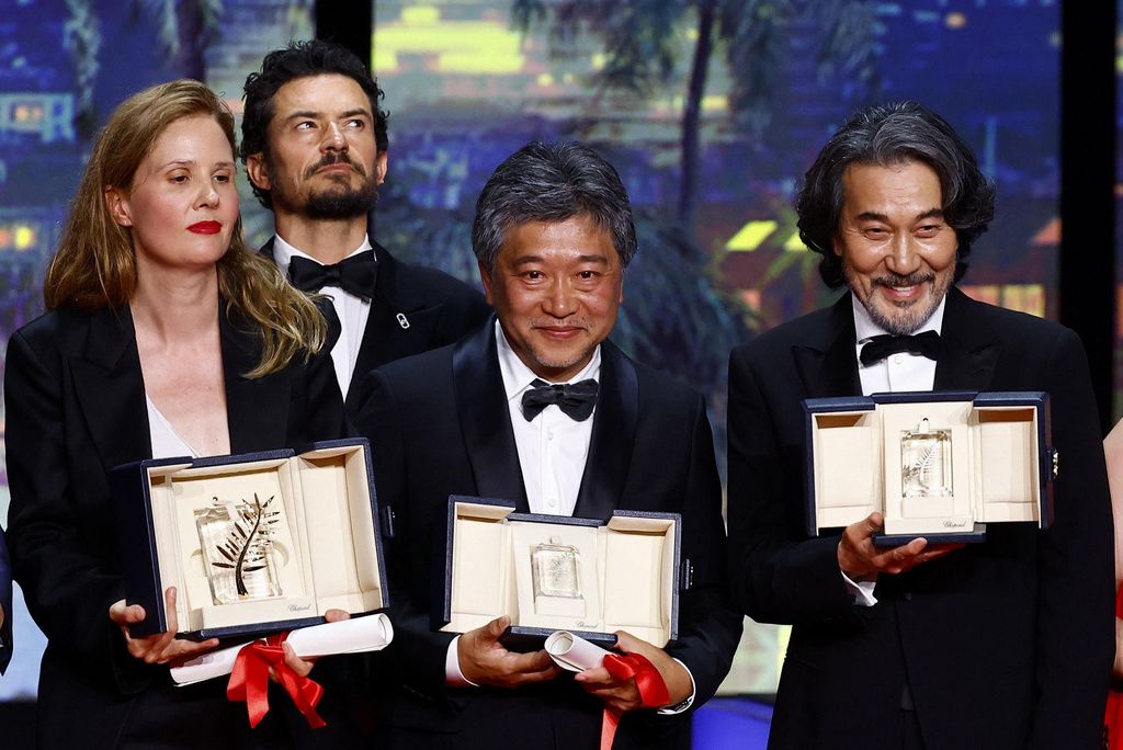 Yakusho Kōji (right) and Koreeda Hirokazu (center) at the Cannes Film Festival on May 27, 2023. (© Reuters/Kyōdō)