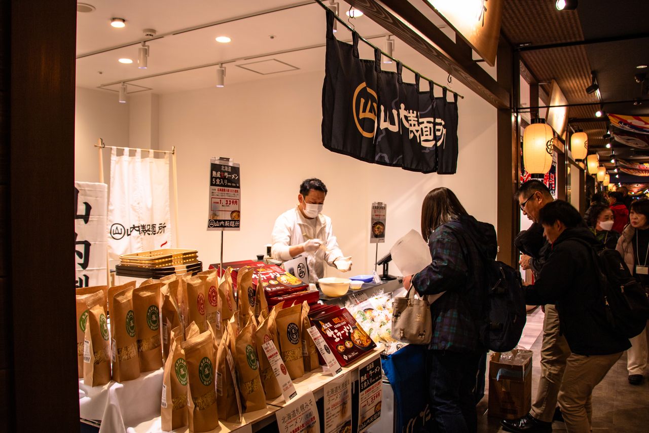 The narrow Mekiki Yokochō is lined with shops selling fresh and dried goods, alongside standing bars, bringing to mind Tsukiji Market in former days. (© Nippon.com)