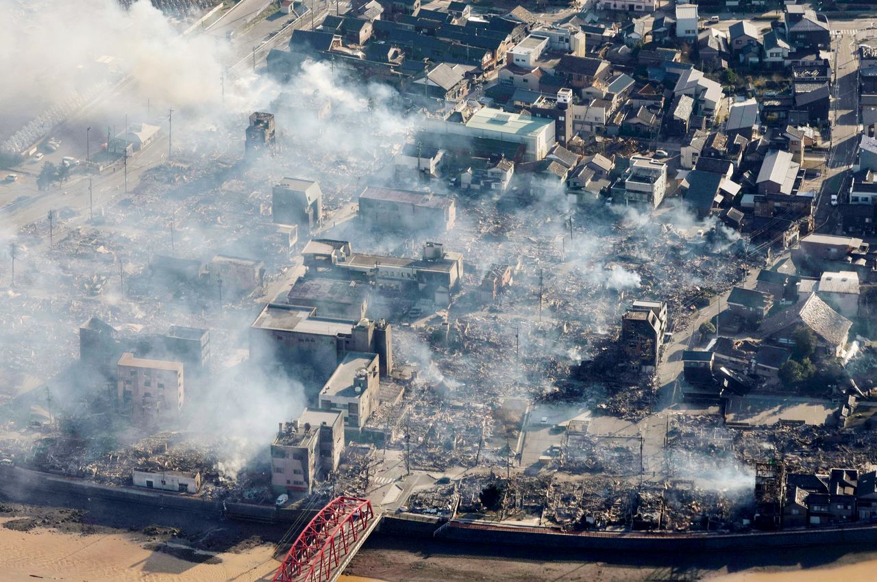Smoke rises from houses in Wajima on January 2, 2024, from fires sparked in the wake of the Noto Peninsula earthquake. (© Jiji)