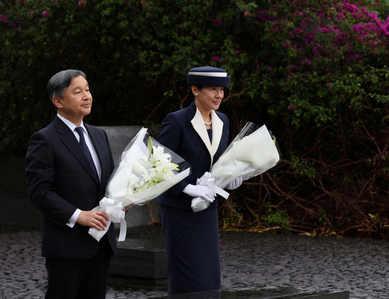Emperor Naruhito and Empress Masako make an offering of flowers on Iōtō (Iwo Jima). (© Reuters)