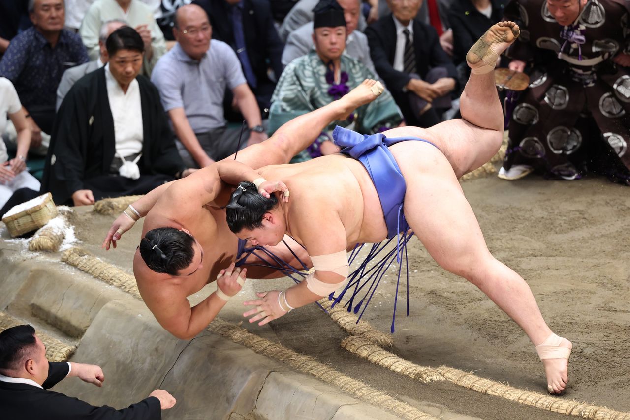 Ōnosato (right) forces Hōshōryū out of the ring in the decisive bout in Tokyo on September 28, 2025. (© Jiji)