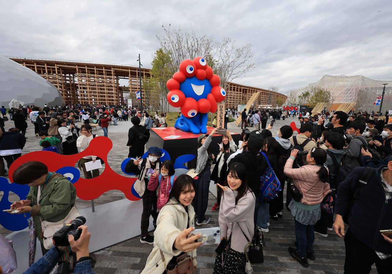 Visitors gather to take pictures with the official Expo mascot Myaku-Myaku on April 13, 2025. (© Jiji)