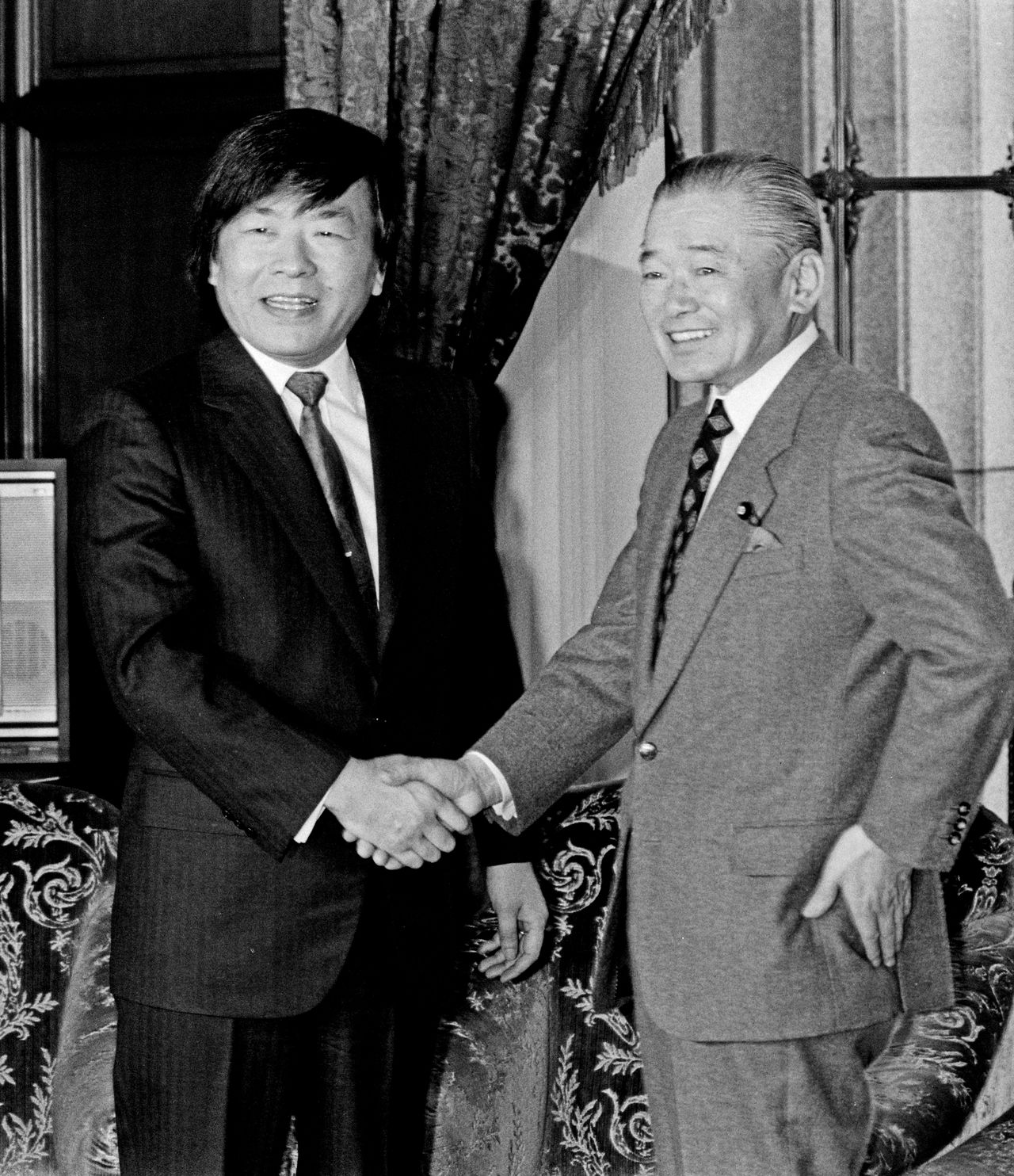 Tonegawa Susumu, at left, shakes hands with Prime Minister Takeshita Noboru in March 1988. (© Jiji)