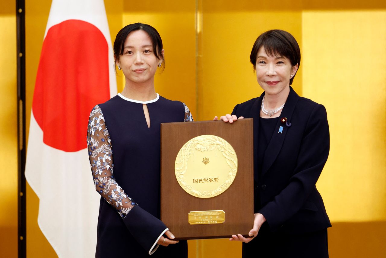 Takagi Miho receives her People’s Honor Award from Prime Minister Takaichi Sanae. (© AFP/Jiji; pool photo)