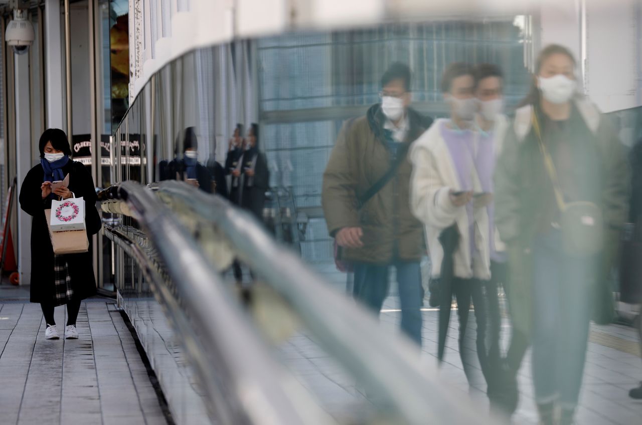 FILE PHOTO: Pedestrians wearing protective masks amid the coronavirus disease (COVID-19) outbreak, make their way in Tokyo, Japan, February 2, 2021. REUTERS/Kim Kyung-Hoon/File Photo