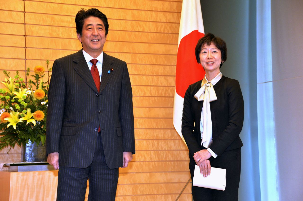 FILE PHOTO: Makiko Yamada and Japan Prime Minister Yoshihide Suga's predecesstor, Shinzo Abe, smile as Abe appoints her as secretary to the prime minister in Tokyo November 29, 2013. REUTERS/Yoshikazu Tsuno/Pool/File Photo