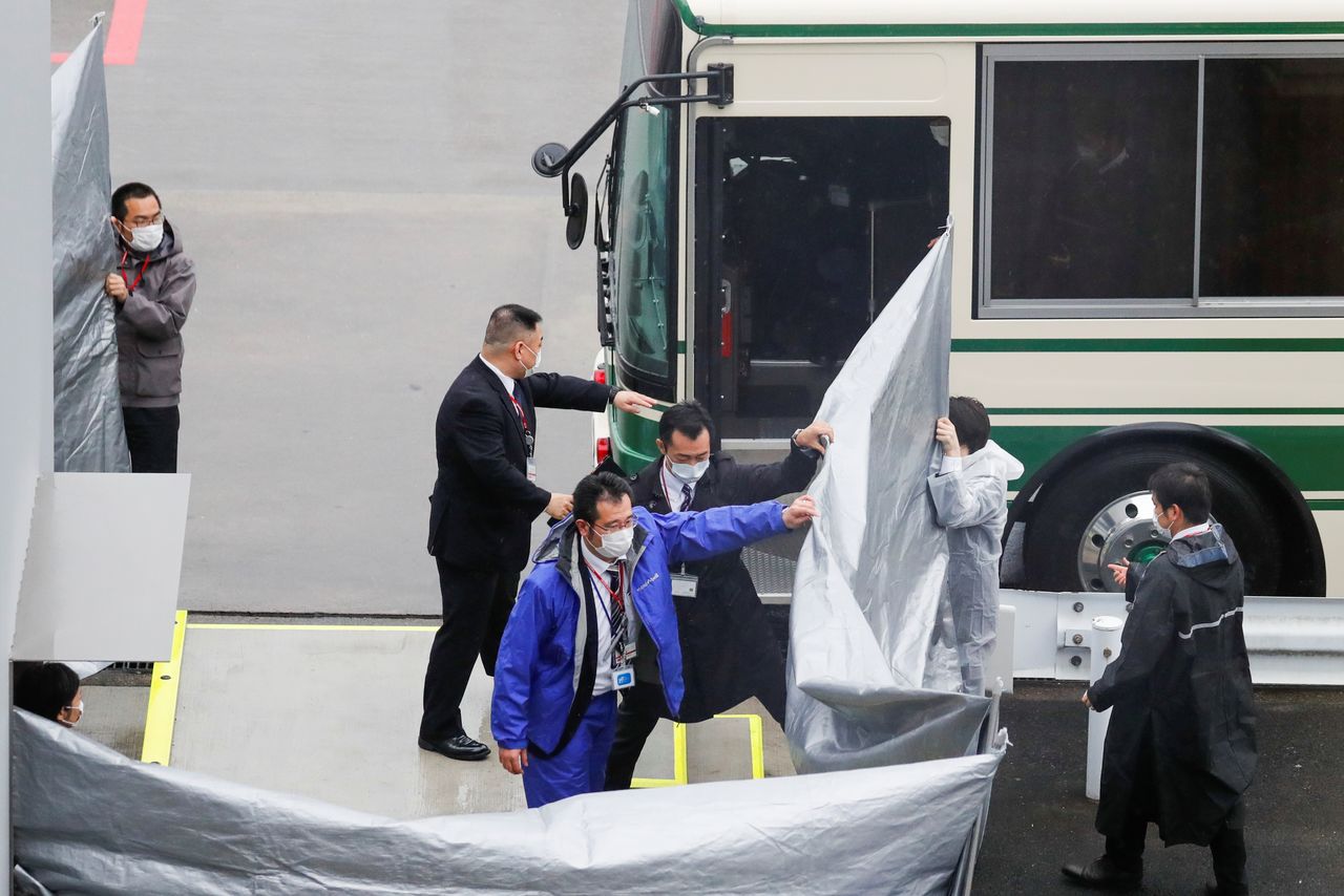 Japanese officers get prepared to escort U.S. citizens Michael Taylor and his son Peter Taylor, suspected of helping former Nissan Motor Chairman Carlos Ghosn to escape to Lebanon, upon their arrival at Narita airport, following their extradition to Japanese Prosecutors, in Chiba, Japan, March 2, 2021. REUTERS/Kim Kyung-Hoon