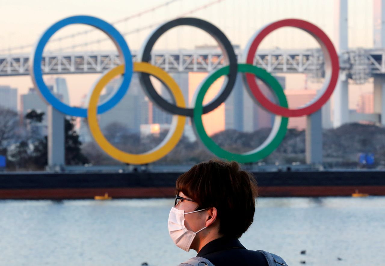 FILE PHOTO: A man wears a protective mask amid the coronavirus (COVID-19) outbreak in front of the giant Olympic rings in Tokyo, Japan, January 13, 2021. REUTERS/Kim Kyung-Hoon/File Photo