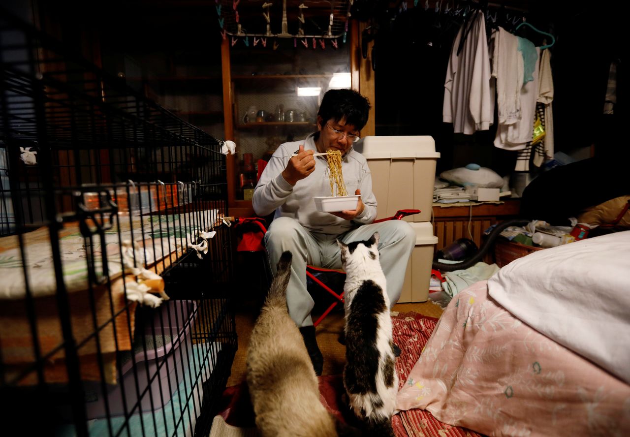 Sakae Kato eats instant noodles for dinner at his home in a restricted zone in Namie, Fukushima Prefecture, Japan, February 20, 2021. Kato looks after 41 cats in his home and another empty building on his property. A decade ago, he stayed behind to rescue cats abandoned by neighbours who fled the radiation clouds belching from the nearby Fukushima nuclear plant. He won't leave. I want to make sure I am here to take care of the last one,