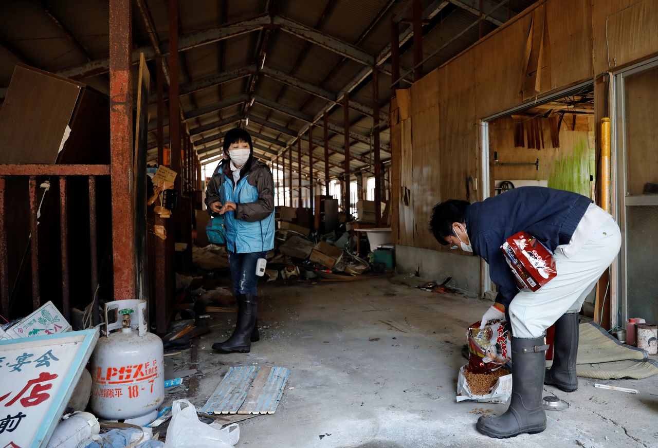 Sakae Kato prepares food for abandoned and feral cats at a barn in a restricted zone in Namie, Fukushima Prefecture, Japan, February 21, 2021. Kato looks after 41 cats in his home and another empty building on his property. A decade ago, he stayed behind to rescue cats abandoned by neighbours who fled the radiation clouds belching from the nearby Fukushima nuclear plant. He won't leave. I want to make sure I am here to take care of the last one,