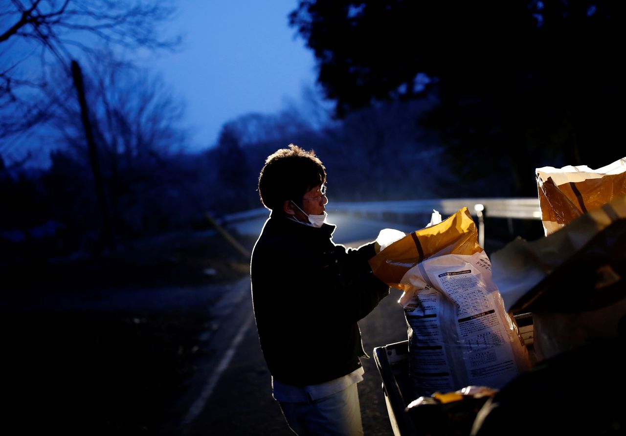 Sakae Kato prepares to feed wild boars in front of his home, in a restricted zone in Namie, Fukushima Prefecture, Japan, February 20, 2021. A decade ago, Kato stayed behind to rescue cats abandoned by neighbours who fled the radiation clouds belching from the nearby Fukushima nuclear plant. He won't leave. I don't want to leave, I like living in these mountains,