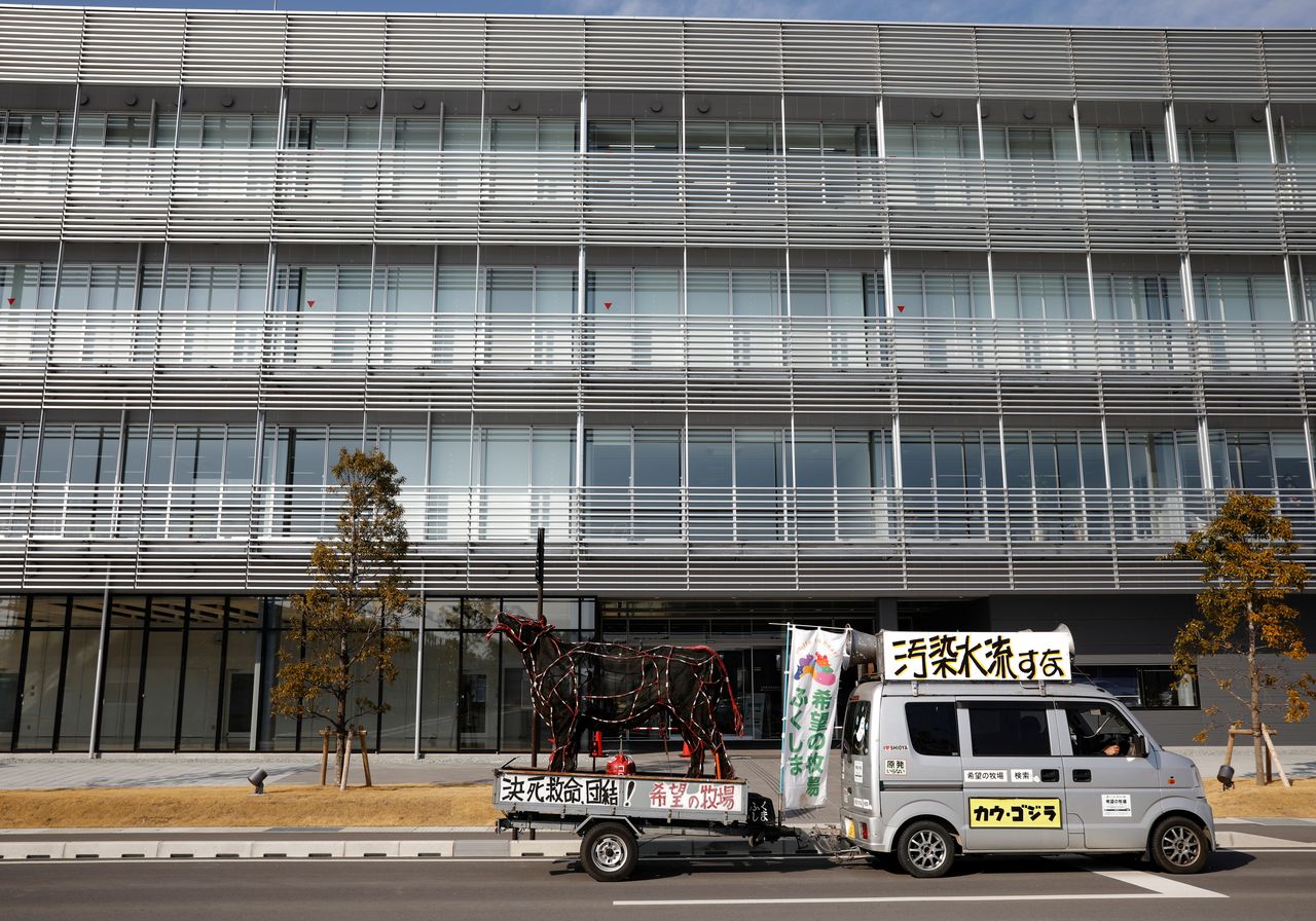 Masami Yoshizawa tows a figure of a bullock from his van, while shouting protest slogans in front of an office building where a unit of Tokyo Electric Power Co operates the Fukushima nuclear plant, in Futaba, Fukushima prefecture, Japan, February 22, 2021. REUTERS/Kim Kyung-Hoon