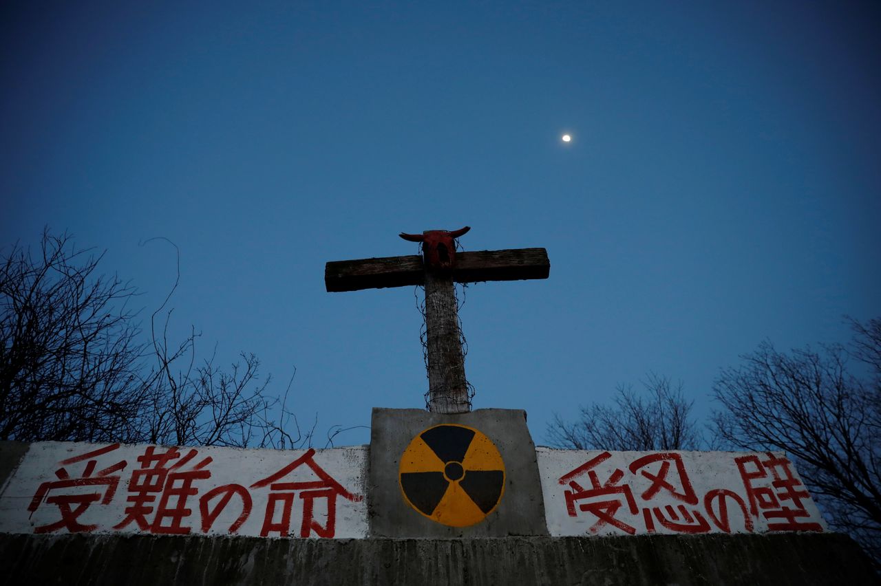 A bullocks's skull sits on top of a cross on a wall that bears a nuclear symbol, at the Ranch of Hope, a cattle farm owned by Masami Yoshizawa, who defied an order to cull his irradiated livestock in protest against the government and Tokyo Electric Power after the Fukushima nuclear disaster, in Namie, Fukushima prefecture, Japan, February 22, 2021. REUTERS/Kim Kyung-Hoon