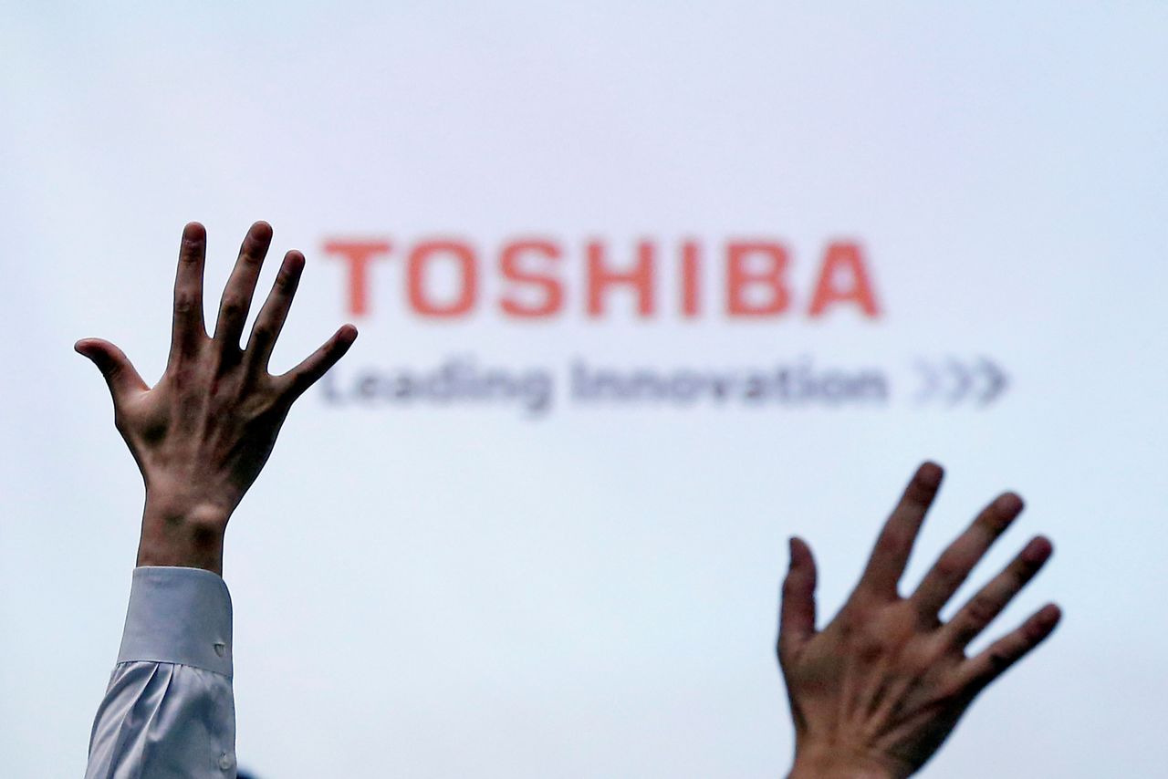 FILE PHOTO: Reporters raise their hands for a question during a Toshiba news conference at the company headquarters in Tokyo, Japan, June 23, 2017. REUTERS/Issei Kato
