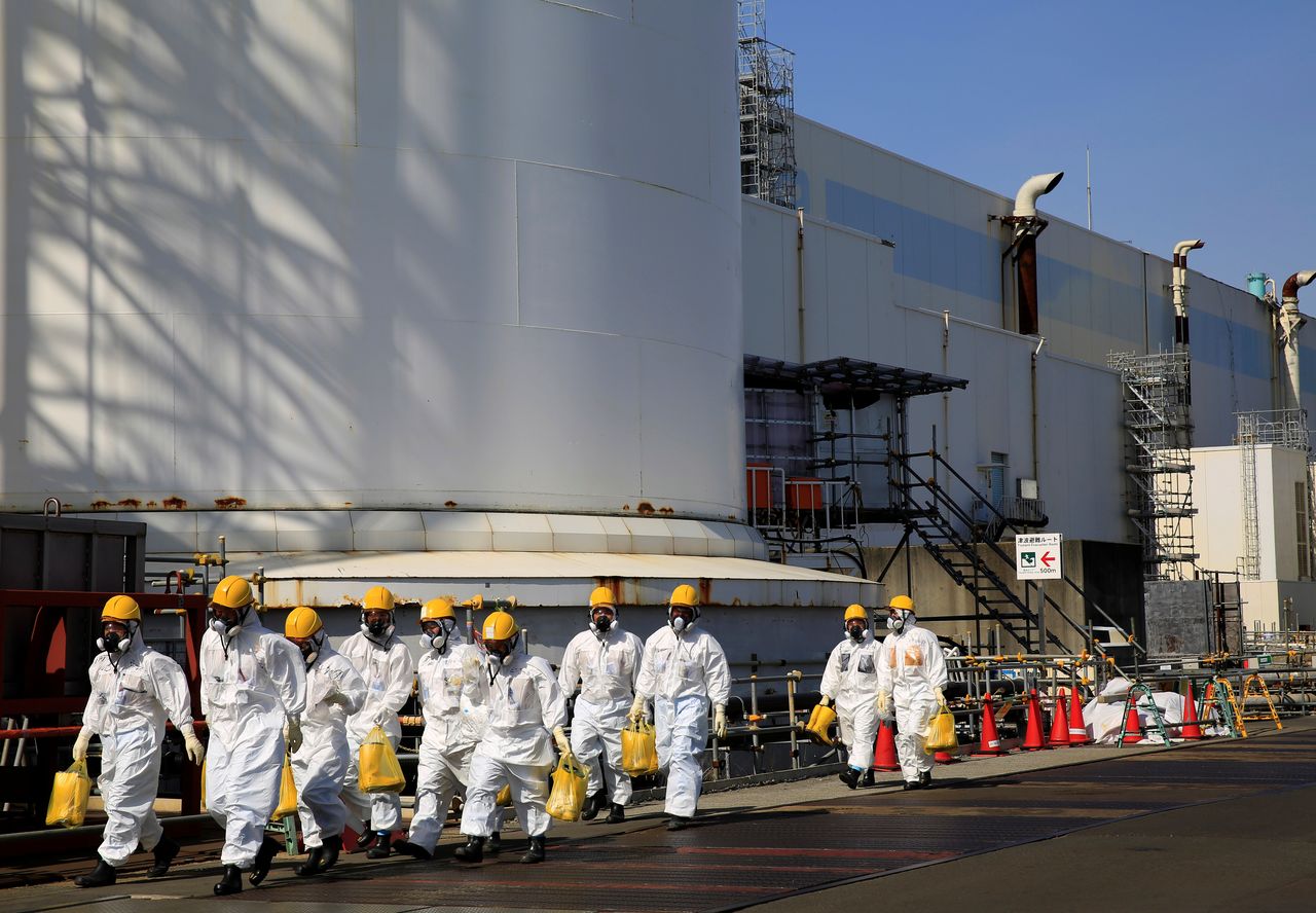 Workers walk near No. 2 and No. 3 reactor buildings at the tsunami-crippled Fukushima Daiichi nuclear power plant in Okuma town, Fukushima prefecture, Japan March 1, 2021. Picture taken March 1, 2021. REUTERS/Sakura Murakami