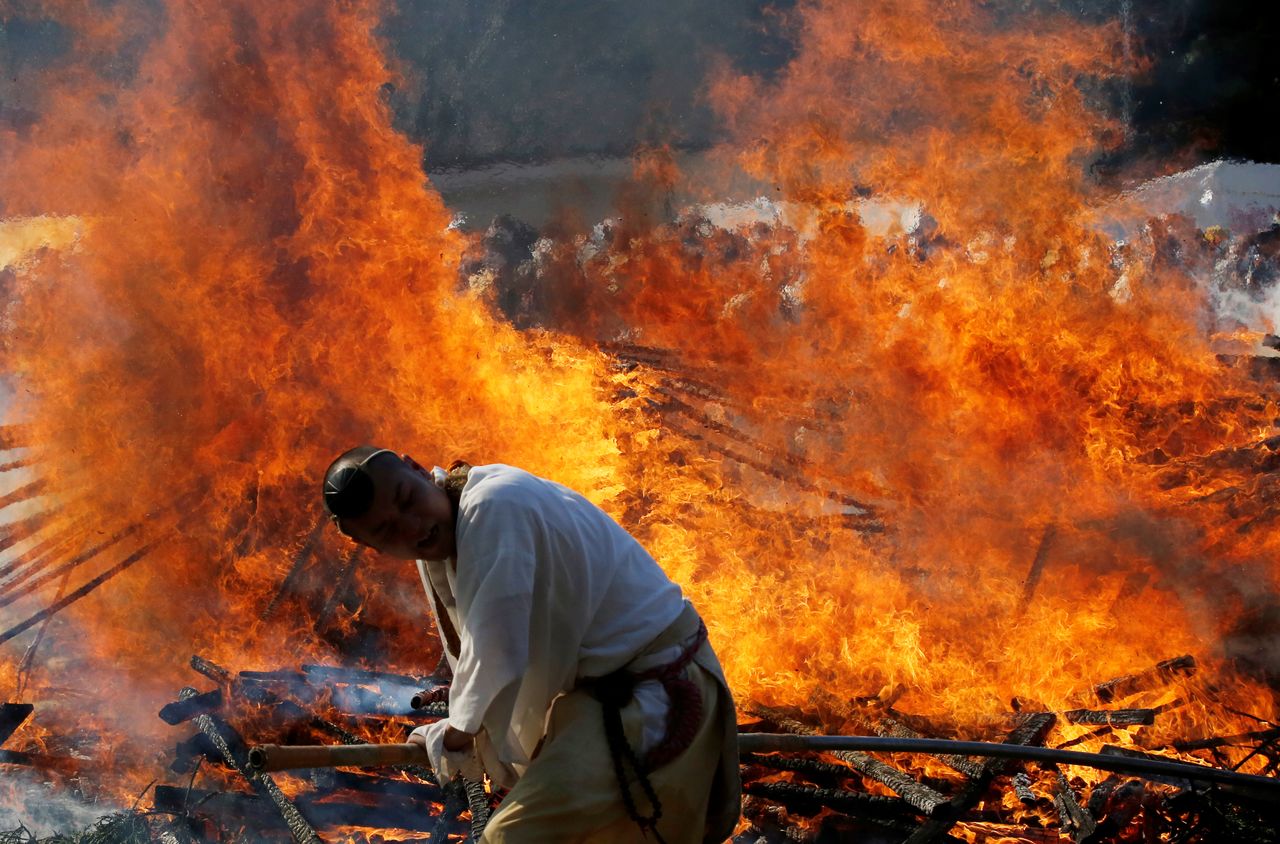 Buddhist monks spreads ambers in a bonfire at the fire-walking festival, called hiwatari matsuri in Japanese, at Mt.Takao in Tokyo, Japan, March 14, 2021. REUTERS/Kim Kyung-Hoon
