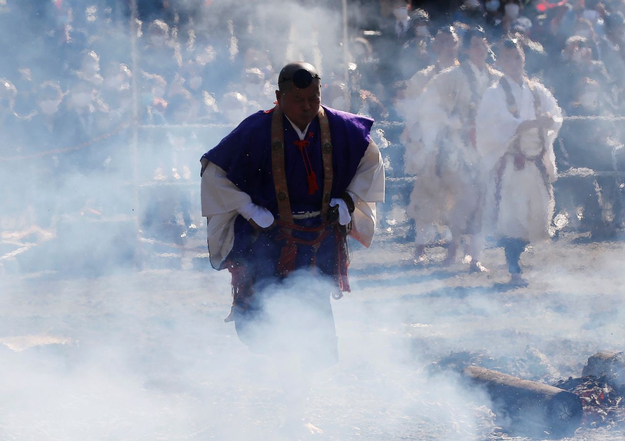 A Buddhist monk walks across smoldering hot ground at the fire-walking festival, called hiwatari matsuri in Japanese, at Mt.Takao in Tokyo, Japan, March 14, 2021. REUTERS/Kim Kyung-Hoon