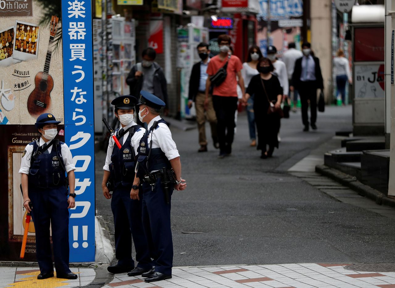 FILE PHOTO: Police officers wearing protective face masks stand guard as the spread of the coronavirus disease (COVID-19) continues, at Shibuya shopping and amusement district in Tokyo, Japan May 25, 2020. REUTERS/Issei Kato/File Photo