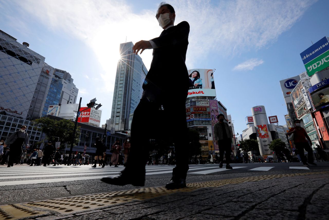 FILE PHOTO: A passersby wearing a protective face mask walks on the Shibuya crossing, amid the coronavirus disease (COVID-19) outbreak, in Tokyo, Japan October 16, 2020. REUTERS/Issei Kato/File Photo