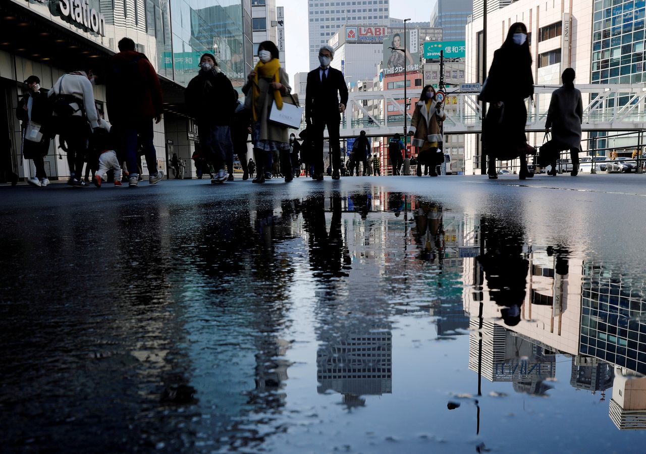 FILE PHOTO: Pedestrians wearing protective masks amid the coronavirus disease (COVID-19) outbreak, make their way in Tokyo, Japan, February 2, 2021. REUTERS/Kim Kyung-Hoon/File Photo