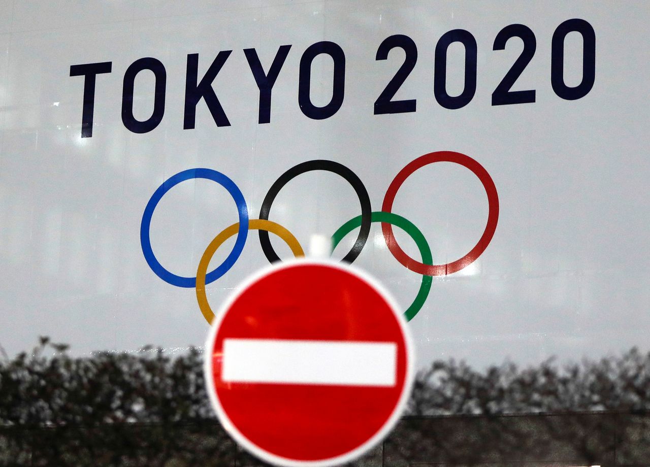 FILE PHOTO: The logo of Tokyo 2020 Olympic Games that have been postponed to 2021 due to the coronavirus disease (COVID-19) outbreak, is seen through a traffic sign at Tokyo Metropolitan Government Office building in Tokyo, Japan January 22, 2021. REUTERS/Issei Kato