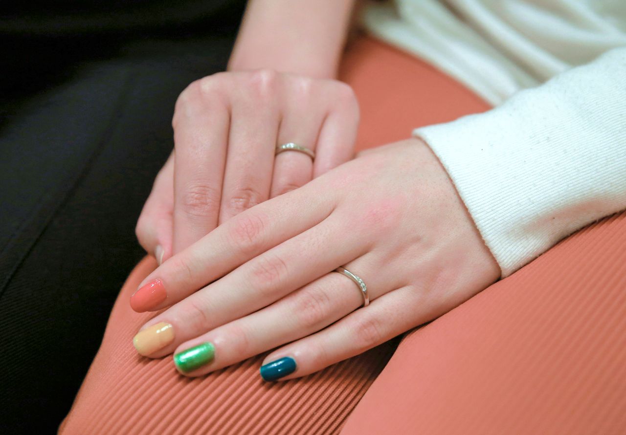 Lesbian couple Jenny and Narumi hold hands during an interview with Reuters at Jenny's parents' house in Tokyo, Japan, March 19, 2021. Picture taken March 19, 2021. REUTERS/Akira Tomoshige