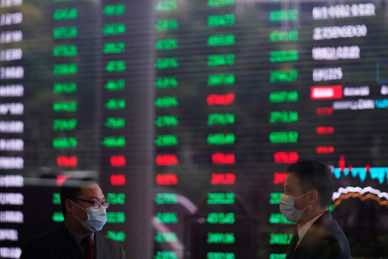 FILE PHOTO: Men wearing face masks are seen inside the Shanghai Stock Exchange building, as the country is hit by a novel coronavirus outbreak, at the Pudong financial district in Shanghai, China February 28, 2020. REUTERS/Aly Song