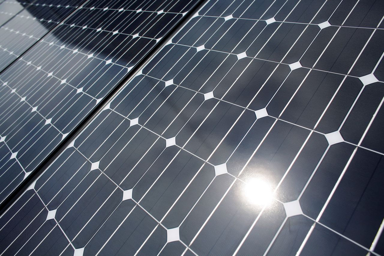 FILE PHOTO: The sun is reflected on a solar panel at a solar power field in Kawasaki, near Tokyo June 13, 2012. REUTERS/Toru Hanai/File Photo
