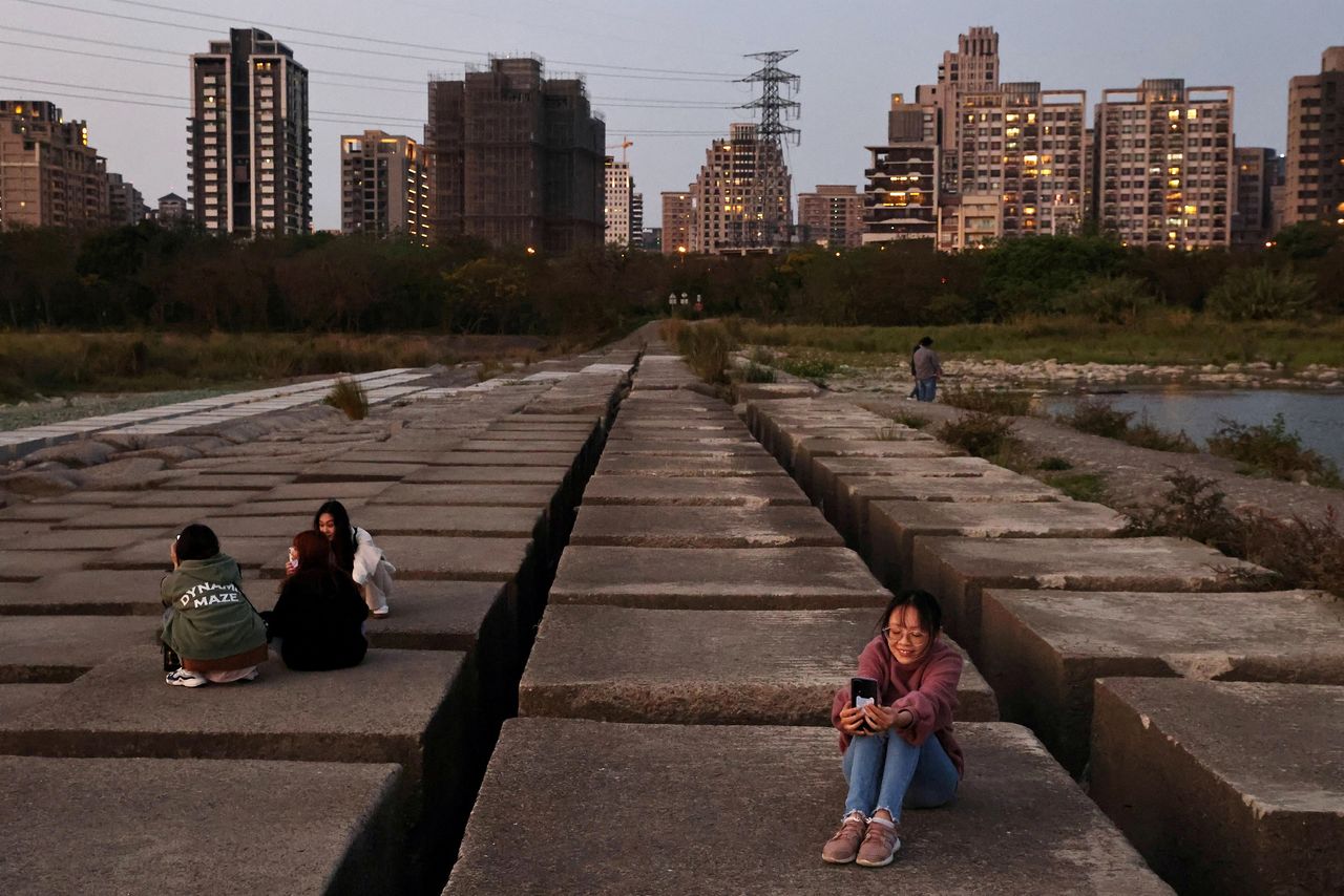 FILE PHOTO: People take photos on the exposed riverbed of Taiwan's Touqian river, a main water source for Hsinchu Science Park where major semiconductor companies are based, in Hsinchu, Taiwan during an island-wide drought, March 12, 2021. Picture taken March 12, 2021. REUTERS/Ann Wang