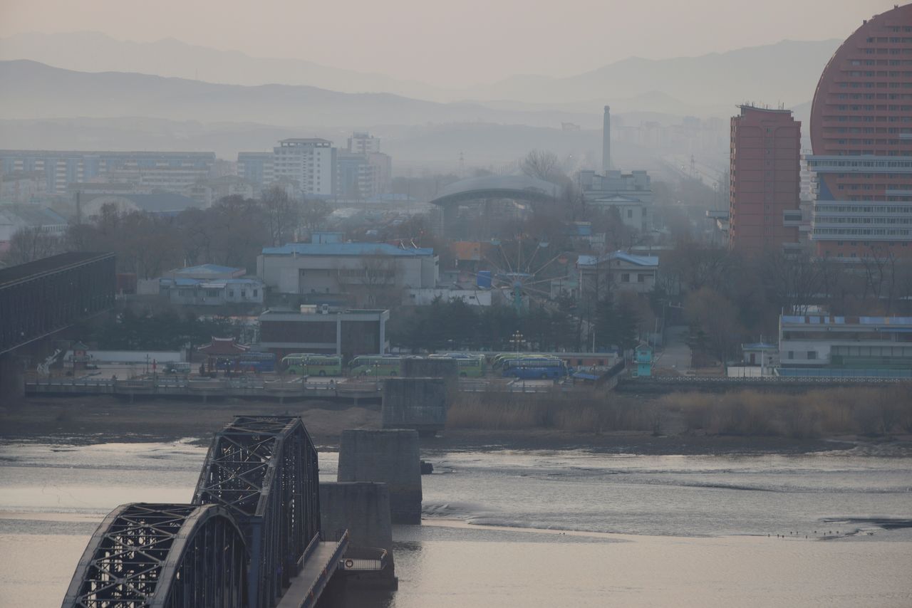 FILE PHOTO: North Korea's Sinuiju and the Broken Bridge over the Yalu river are seen from Dandong, Liaoning province, China March 19, 2021. REUTERS/Carlos Garcia Rawlins/File Photo