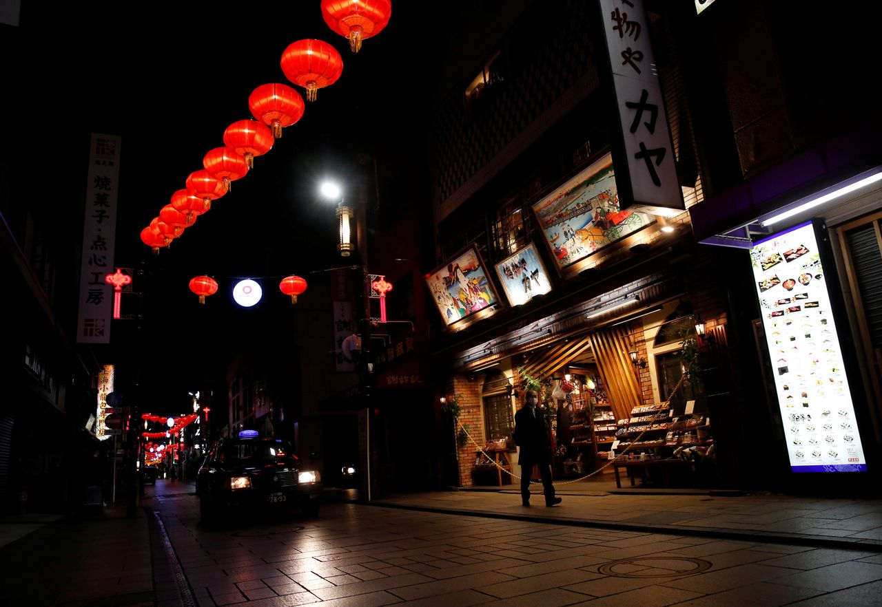 FILE PHOTO: A man wearing a protective mask walks in a street where shops and restaurants are closed after the government declared the second state of emergency for the capital and some prefectures, amid the coronavirus disease (COVID-19) outbreak, at China town in Yokohama, Kanagawa Prefecture, Japan, January 8, 2021. REUTERS/Kim Kyung-Hoon