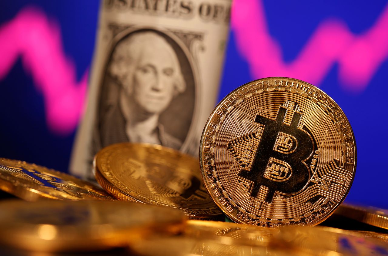 FILE PHOTO: A representation of virtual currency Bitcoin and U.S. One Dollar banknote are seen in front of a stock graph in this illustration taken January 8, 2021. REUTERS/Dado Ruvic