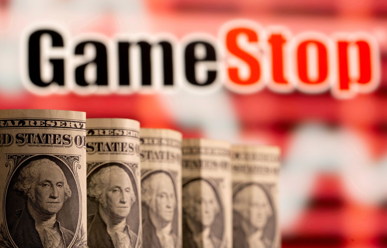 FILE PHOTO: U.S. one dollar banknotes are seen in front of displayed GameStop logo in this illustration taken February 8, 2021. REUTERS/Dado Ruvic/Illustration/File Photo