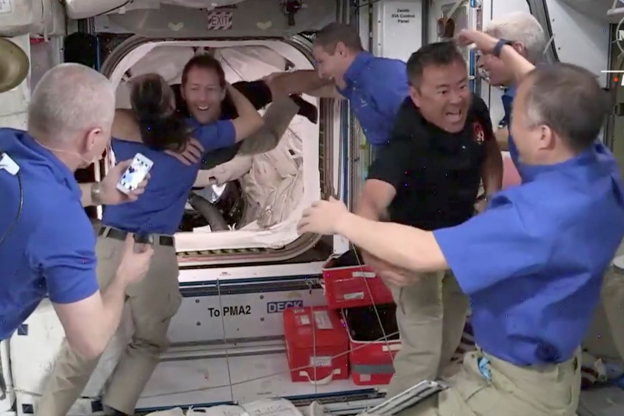 Crew 2 member JAXA astronaut Akihiko Hoshide of Japan is embraced by his compatriot Crew 1 member JAXA astronaut Soichi Noguchi as he and ESA astronaut Thomas Pesquet of France are welcomed as they arrive aboard the International Space Station, after docking SpaceX