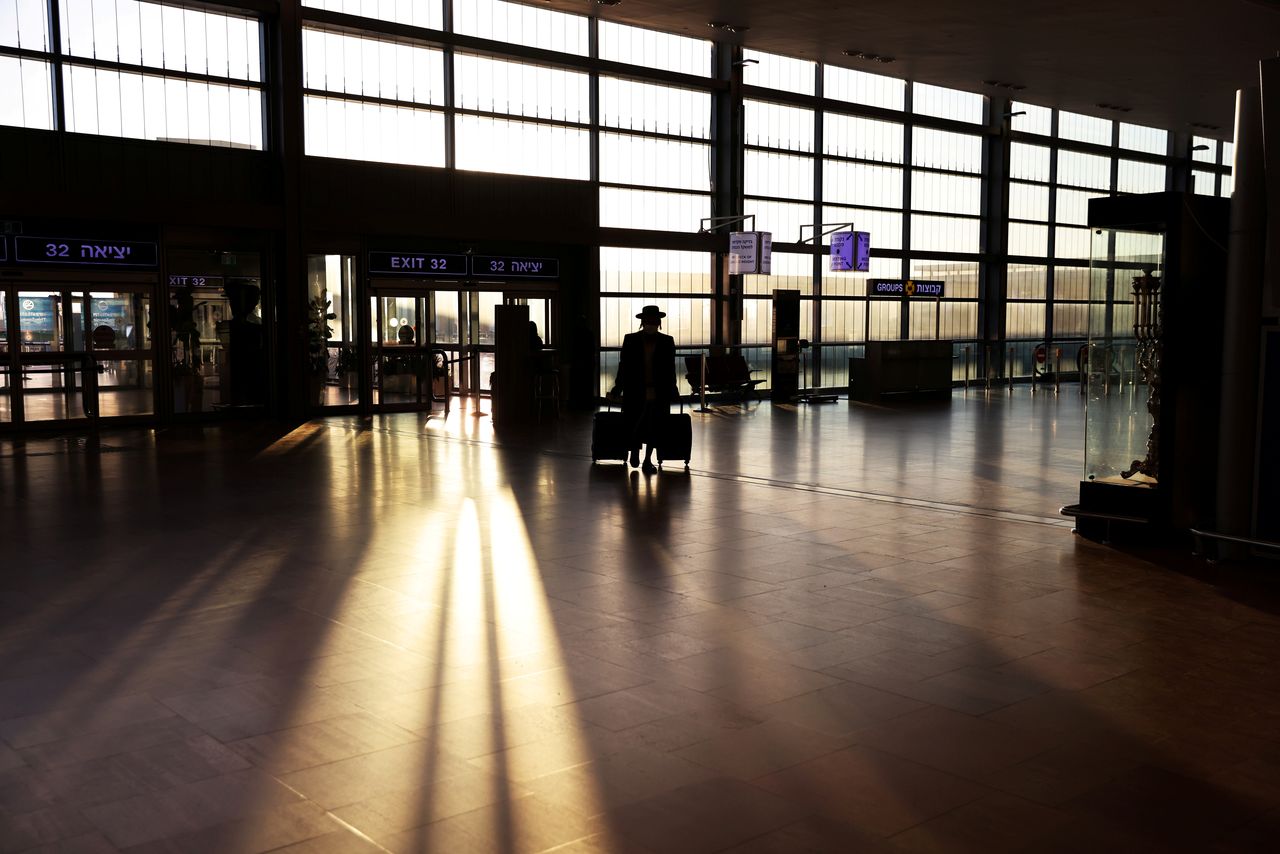 FILE PHOTO: A passenger arrives to a terminal at Ben Gurion international airport before Israel bans international flights, taking effect from Monday midnight until the end of January, in order to stop the spread of the coronavirus disease (COVID-19) and new coronavirus strains, in Lod near Tel Aviv, Israel January 25, 2021. REUTERS/Ronen Zvulun/File Photo