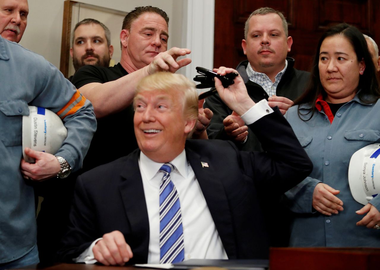 FILE PHOTO: U.S. President Donald Trump gives out pens he used to sign presidential proclamations placing tariffs on steel and aluminum imports to workers from the steel and aluminum industries at the White House in Washington, U.S. March 8, 2018. REUTERS/Leah Millis
