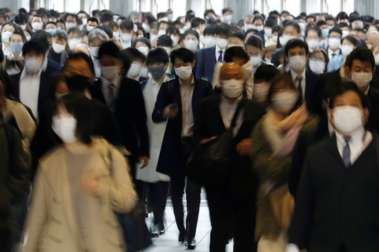 FILE PHOTO: Commuters wearing protective face masks, amid the coronavirus disease (COVID-19) pandemic, make their way in Tokyo, Japan, April 6, 2021. REUTERS/Kim Kyung-Hoon/File Photo