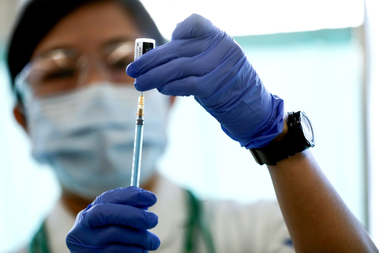 FILE PHOTO: A medical worker fills a syringe with a dose of the Pfizer-BioNTech coronavirus disease (COVID-19) vaccine as Japan launches its inoculation campaign, at Tokyo Medical Center in Tokyo, Japan February 17, 2021. Behrouz Mehri/Pool via REUTERS/File Photo