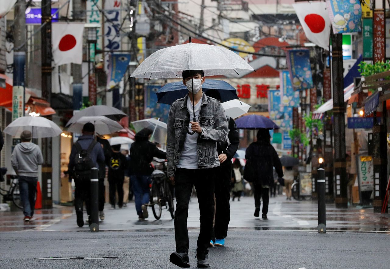 FILE PHOTO: A man wearing a protective face mask, amid the coronavirus disease (COVID-19) pandemic, makes his way at a local shopping street in Tokyo, Japan, May 5, 2021. REUTERS/Kim Kyung-Hoon