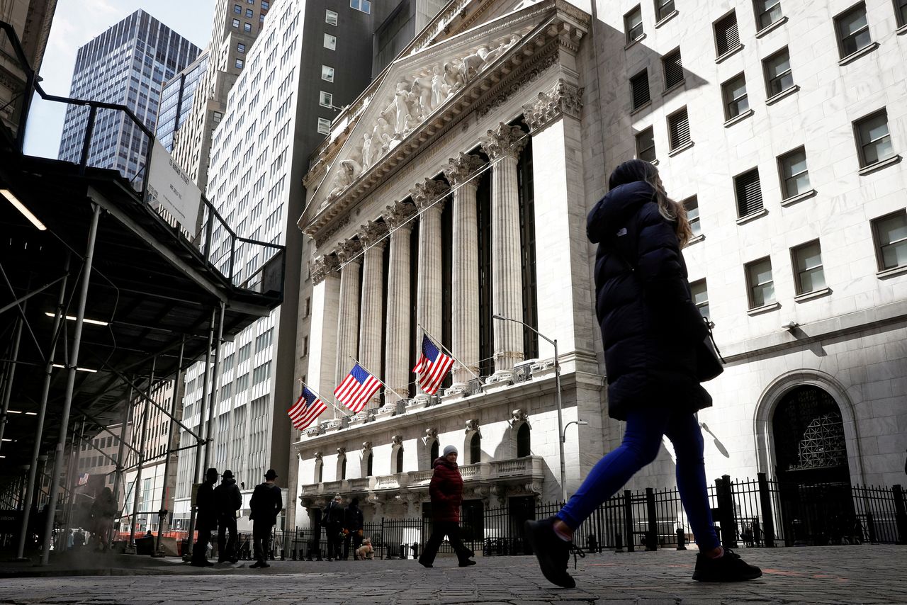 FILE PHOTO: People are seen on Wall Street outside the New York Stock Exchange (NYSE) in New York City, U.S., March 19, 2021. REUTERS/Brendan McDermid/File Photo