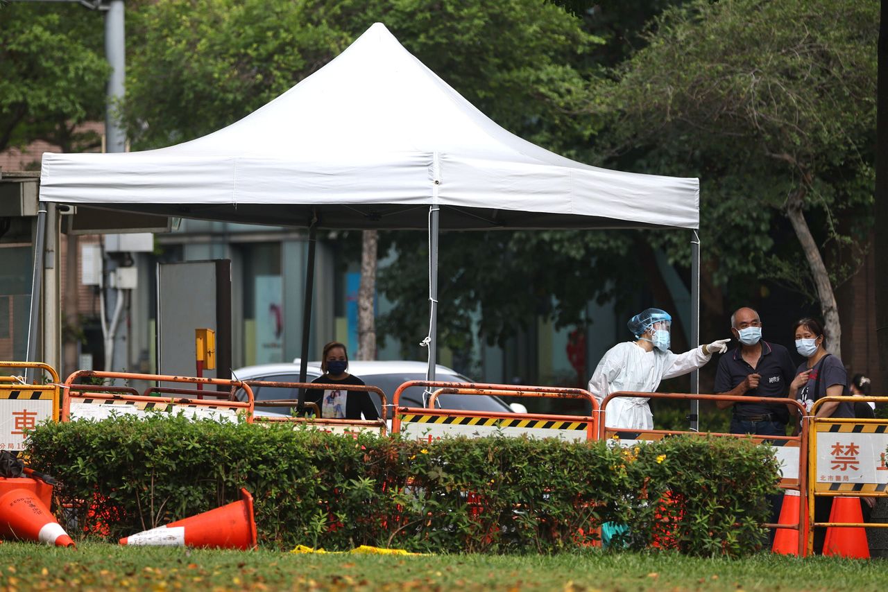 A medical worker guides people on how to get a rapid test following a surge of coronavirus disease (COVID-19) infections in Taipei, Taiwan, May 19, 2021. REUTERS/Ann Wang