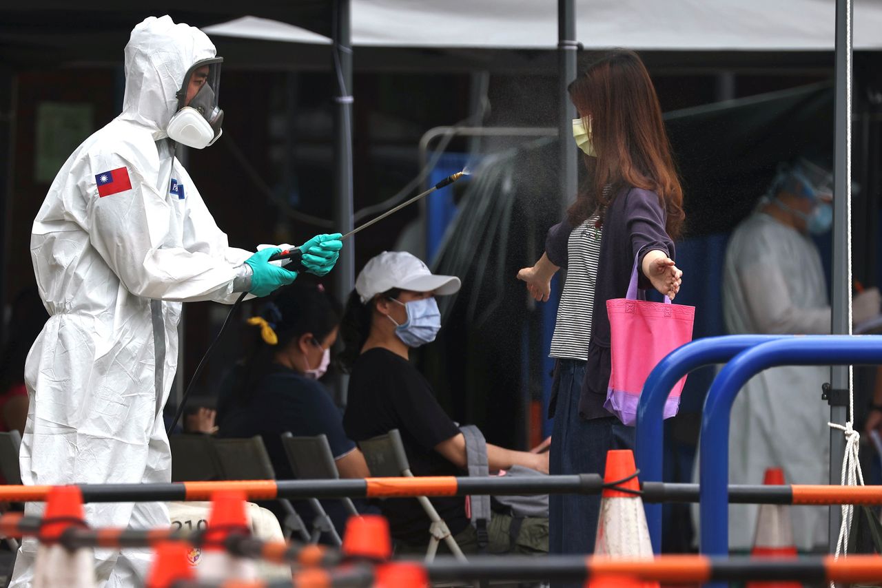 A soldier disinfects a person who is leaving a coronavirus disease (COVID-19) testing site following a surge of coronavirus disease (COVID-19) infections in Taipei, Taiwan May 19, 2021. REUTERS/Ann Wang